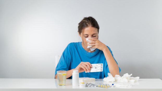 A woman is treated for flu and runny nose, takes pills. High quality photo