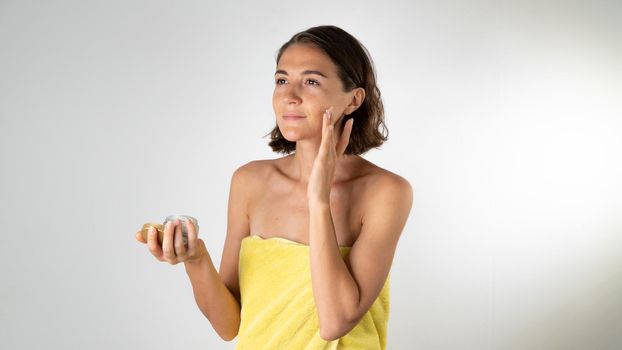 A woman applies the cream on the face - spa at home. High quality photo