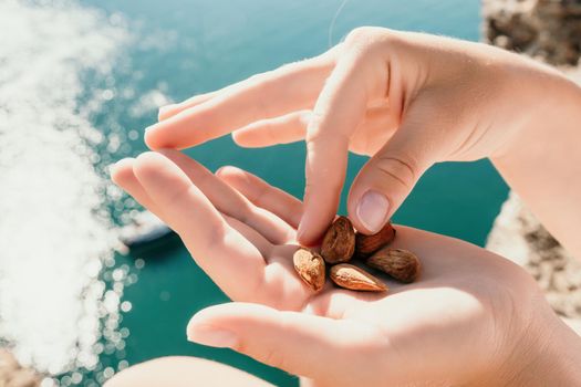 Unrecognizable caucasian woman eating young milky almond nuts. Healthy vegan food