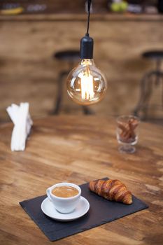 Close up of delicious cup of coffee with parisian dessert. Wooden table. Coffee aroma.