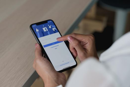 CHIANG MAI, THAILAND - SEP 09, 2022 : A man holds Apple iPhone 6S with facebook application on the screen.facebook is a photo-sharing app for smartphones.