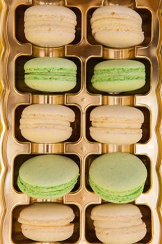 Traditional french sweets macarons in a golden box. Sweet dessert