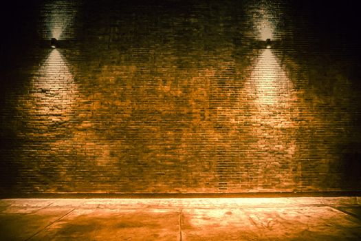 old room with brick wall, grungy background . brick wall with bulb lights lamp. nice brick show room with spotlights. Background of an empty corridor with brick wall
