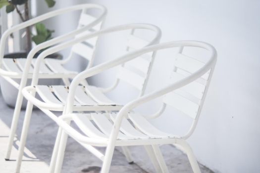 empty white metal chair in line with white wall new normal covid 19 service