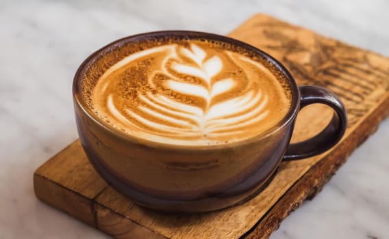 A cup of coffee latte top view with leaf shape foam