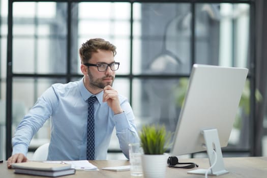 Young cheerful businessman working at office