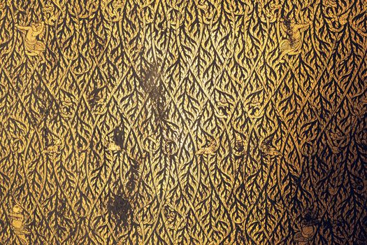 Thai traditional  gold leaf painting art on temple door