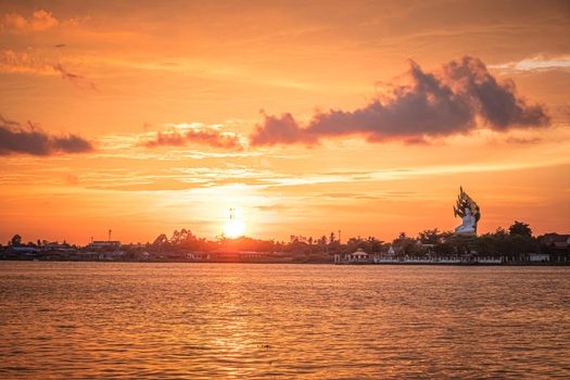 Silhouette of tree at sunset. Golden sun sunset reflect on surface of water nature background.