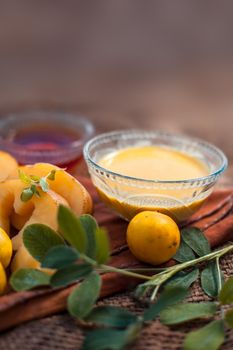 Face mask for the treatment of pigmentation on jute bags surface consisting of potato,lemon juice,honey and rice flour in a glass bowl.Entire constituents on the surface.Vertical shot.