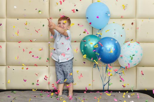 Boy rejoices with confetti and balloons for his birthday