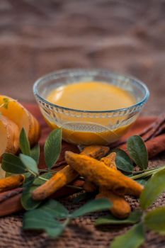 Potato face mask consisting of grated potato and some turmeric powder or haldi in a glass bowl on jute bags surface to brighten the skin, kills bacteria and germs.