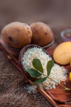 Face mask for the treatment of pigmentation on jute bags surface consisting of potato,lemon juice,honey and rice flour in a glass bowl.Entire constituents on the surface.Vertical shot.