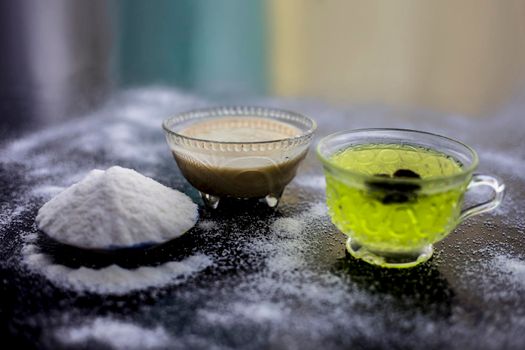 Rice flour and rice grain on wooden surface along with some green tea in a transparent glass cup and a star anise in it.Face mask for the treatment for smoother skin.
