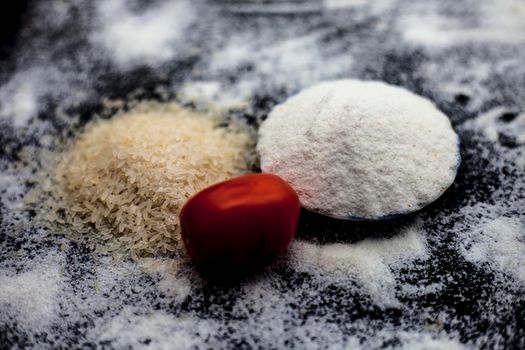 Face mask for oily skin on wooden surface consisting of rice flour,honey,tomato juice in a glass bowl along with some rice flour spread on the surface for greater effect.Horizontal shot.