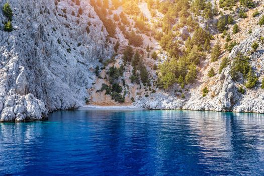 Saint George bay on Symi island, popular stop over for tourists to have a swim in the turquoise waters, Symi island, Greece. Boat sailing at the Symi island and part of the Dodecanese island group.