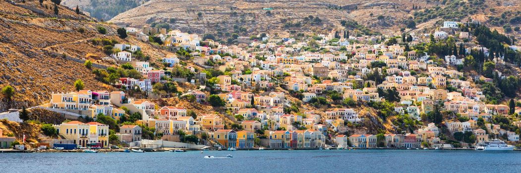 View of the beautiful greek island of Symi (Simi) with colourful houses and small boats. Greece, Symi island, view of the town of Symi (near Rhodes), Dodecanese.