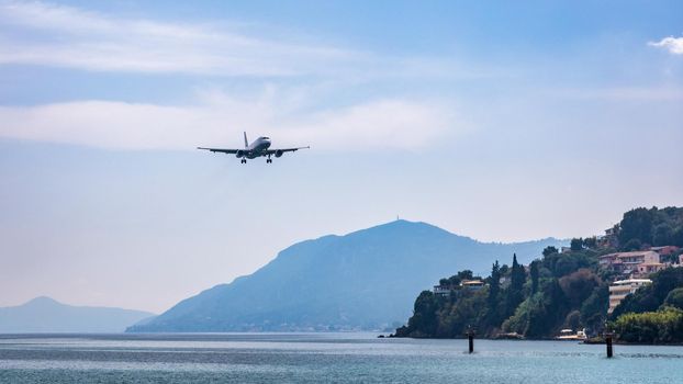 Landing airplane. Landscape with passenger airplane is flying in the blue sky with clouds. Passenger airliner. Business trip. Commercial aircraft. Passenger airplane flying and getting ready to land.