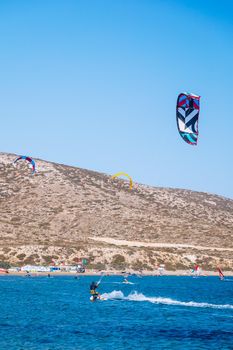 Surfers in Prasonisi Beach in Rhodes island, Greece. Kiteboarder kitesurfer athlete performing kitesurfing kiteboarding tricks. Prasonisi Beach is popular location for surfing. Greece