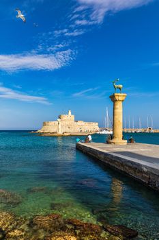 Mandraki port with deers statue, where The Colossus was standing and fort of St. Nicholas. Rhodes, Greece. Hirschkuh statue in the place of the Colossus of Rhodes, Rhodes, Greece