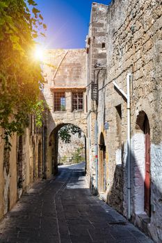 Medieval arched street in the old town of Rhodes, Greece. Rhodes old town in Rhodes island in Greece. Historical streets of old town Rhodes with flowers in Rhodes, Dodecanese, Greece