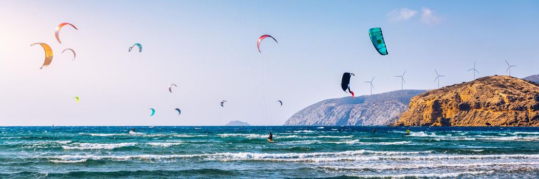 Surfers in Prasonisi Beach in Rhodes island, Greece. Kiteboarder kitesurfer athlete performing kitesurfing kiteboarding tricks. Prasonisi Beach is popular location for surfing. Greece