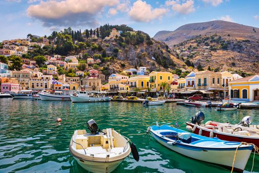 View on Symi (Simi) island harbor port, classical ship yachts, houses on island hills, Aegean Sea bay. Greece islands holidays vacation travel tours from Rhodos island. Symi, Greece,  Dodecanese.