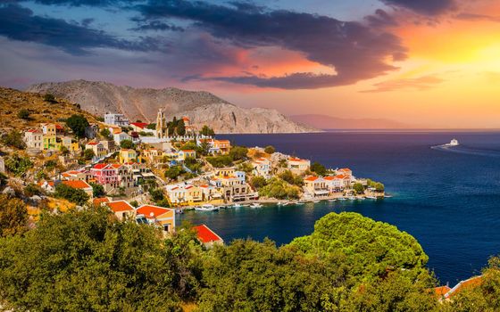 View of the beautiful greek island of Symi (Simi) with colourful houses and small boats. Greece, Symi island, view of the town of Symi (near Rhodes), Dodecanese.