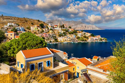 View on Symi (Simi) island harbor port, classical ship yachts, houses on island hills, Aegean Sea bay. Greece islands holidays vacation travel tours from Rhodos island. Symi, Greece,  Dodecanese.