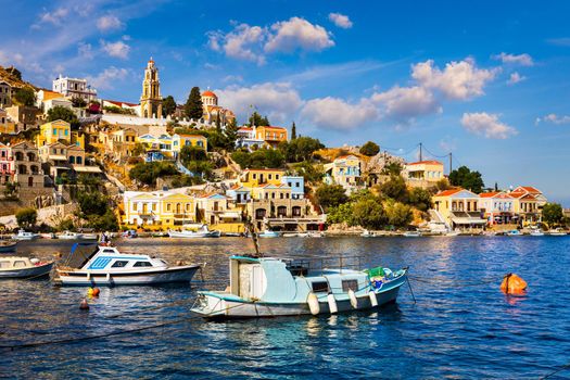 View on Symi (Simi) island harbor port, classical ship yachts, houses on island hills, Aegean Sea bay. Greece islands holidays vacation travel tours from Rhodos island. Symi, Greece,  Dodecanese.