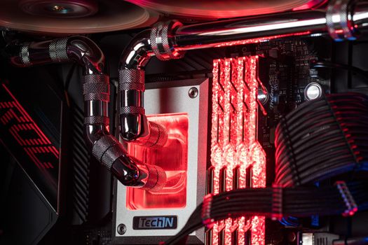 Prague, Czech Republic - 21 July 2021: Close-up of high performance Desktop PC and water cooling system with multicolored LED RGB light show status on working, interior on Computer PC Case and DIY