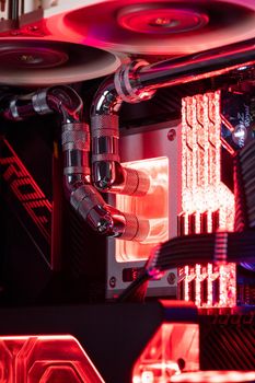Prague, Czech Republic - 21 July 2021: Close-up of high performance Desktop PC and water cooling system with multicolored LED RGB light show status on working, interior on Computer PC Case and DIY