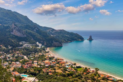 Agios Gordios exotic beach in Corfu island,Greece. Agios Gordios beach, Corfu island, Greece. Panoramic view of the Agios Gordios beach, sandy seashore with beach umbrellas and deck chairs.