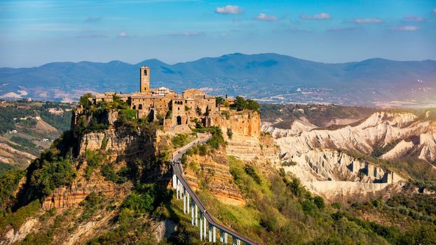 The famous Civita di Bagnoregio on a sunny day. Province of Viterbo, Lazio, Italy. Medieval town on the mountain, Civita di Bagnoregio, popular touristic stop at Tuscany, Italy.