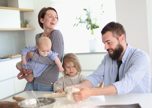 Young family with daughter and son in the kitchen