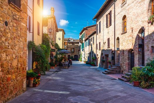 Cozy street decorated with colorful flowers, Pienza, Tuscany, Italy, Europe. Narrow street in the charming town of Pienza in Tuscany. Beautiful streets of the small and historic village Pienza, Italy