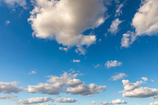 Sunny sky abstract background, beautiful cloudscape, on the heaven, view over white fluffy clouds, freedom concept. Aerial view of sky and white clouds. View from airplane. 