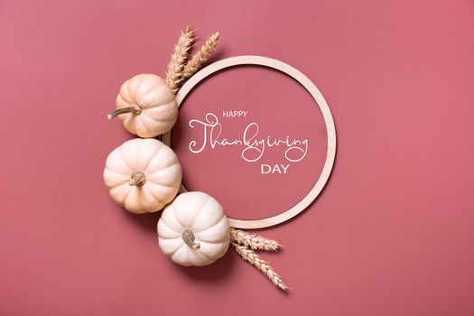 Happy thanksgiving day greeting card with decorative pumpkins and wooden frame top view, flat lay.