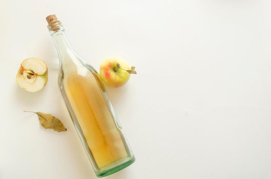 Top view, a bottle of a apple cider vinegar with apple composition on white background.