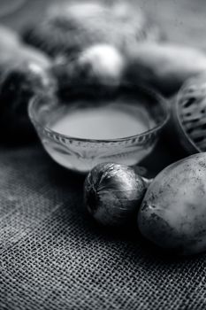 Best earth growth-boosting potion consisting of ingredients which are potato juice and onion juice in a glass bowl along with raw potato and onion on the surface.