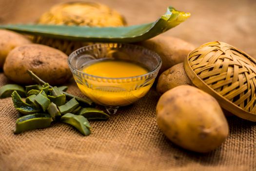 Homemade conditioner and shampoo for dandruff and scalp cleaning on jute bag's surface i.e. potato juice well mixed with aloe vera gel in a glass bowl along with raw potato and some aloe vera leaf.