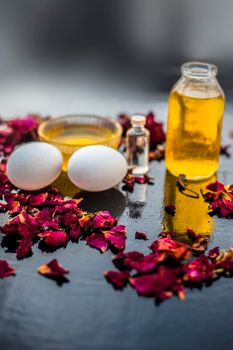 Trio pack of herbs and ingredients to fight dandruff on the wooden surface well mixed in a glass bowl which are castor oil, coconut oil, and egg. Also used to treat itchiness and to deep condition.