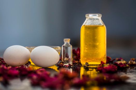 Trio pack of herbs and ingredients to fight dandruff on the wooden surface well mixed in a glass bowl which are castor oil, coconut oil, and egg. Also used to treat itchiness and to deep condition.