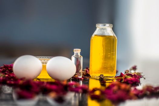 Trio pack of herbs and ingredients to fight dandruff on the wooden surface well mixed in a glass bowl which are castor oil, coconut oil, and egg. Also used to treat itchiness and to deep condition.