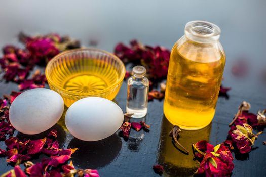 Trio pack of herbs and ingredients to fight dandruff on the wooden surface well mixed in a glass bowl which are castor oil, coconut oil, and egg. Also used to treat itchiness and to deep condition.