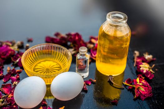 Trio pack of herbs and ingredients to fight dandruff on the wooden surface well mixed in a glass bowl which are castor oil, coconut oil, and egg. Also used to treat itchiness and to deep condition.