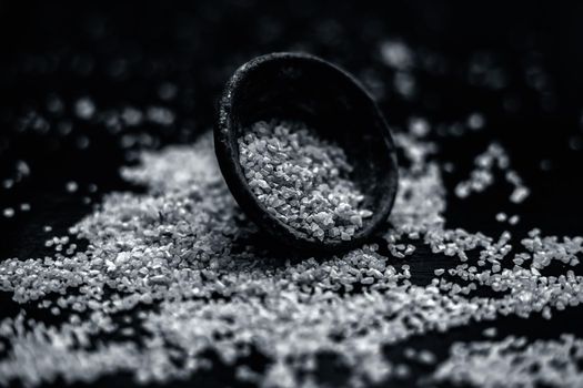 Raw oats in a black colored clay bowl on the black surface.