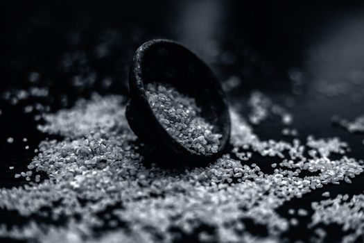 Raw oats in a black colored clay bowl on the black surface.