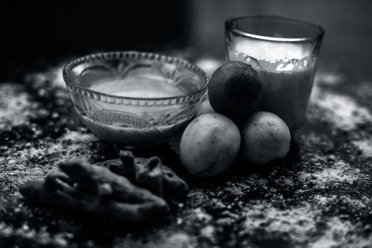 Lemon face mask on the wooden surface consisting lemon juice, gram flour or chickpea flour, turmeric or Haldi and milk in a glass bowl.For the treatment of tans.