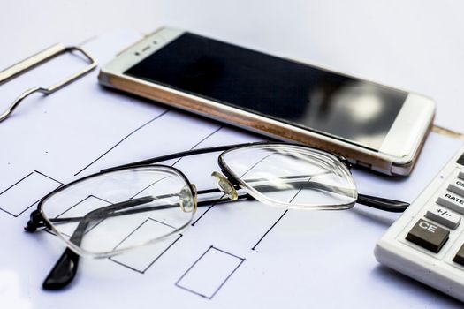 Close up of workplace of businessman or finance consultant isolated on white using credit card, cell phone, pen and calculator like things and some coins also.