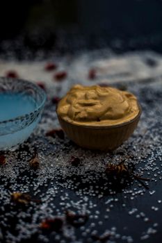 Ubtan/face mask/face pack of Multani mitti or fuller's earth on wooden surface in a glass bowl consisting of Multani mitti and coconut oil for the remedy or treatment of suntan.On the wooden surface.